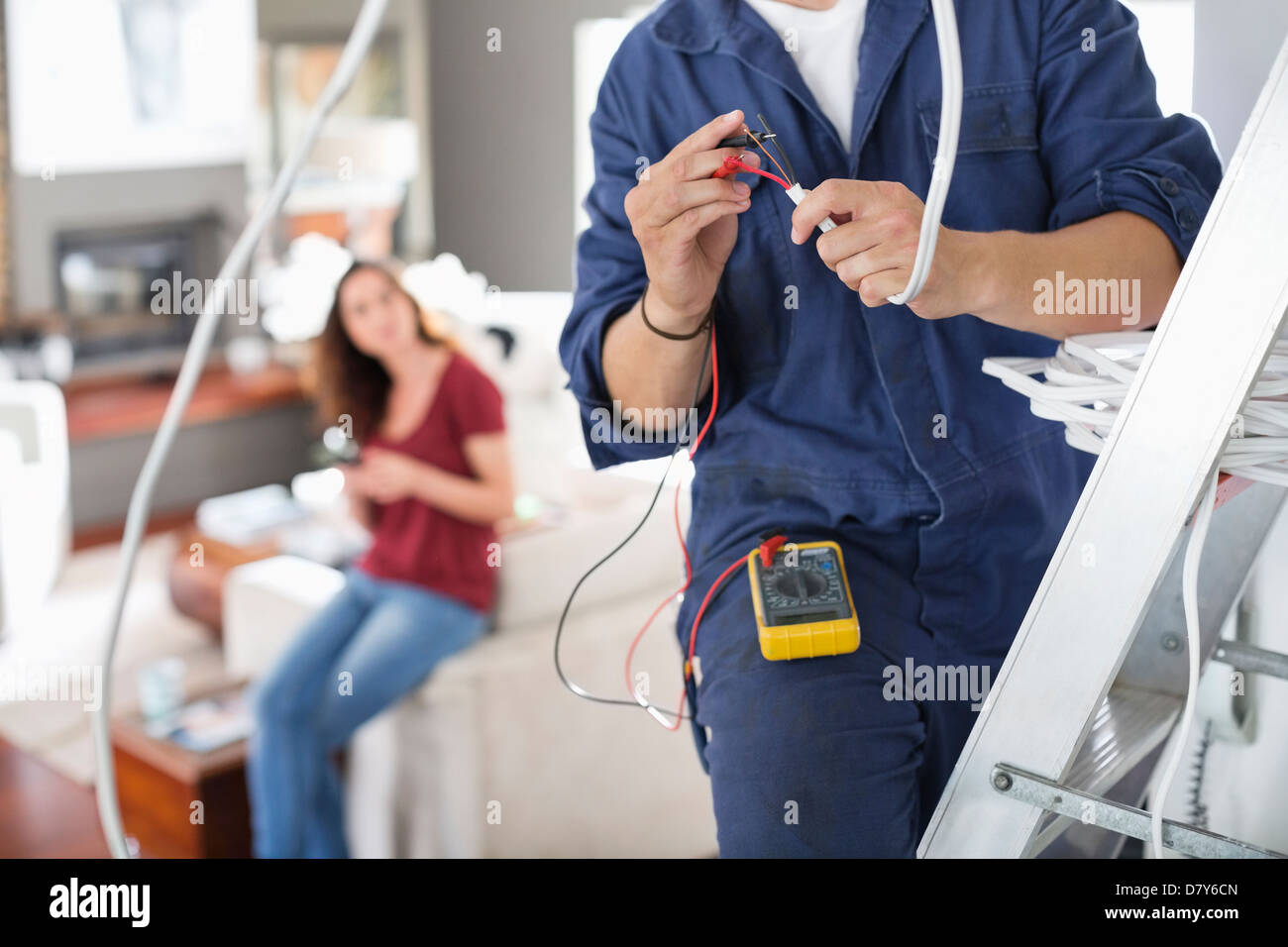 Elektriker arbeiten im Wohnzimmer Stockfoto