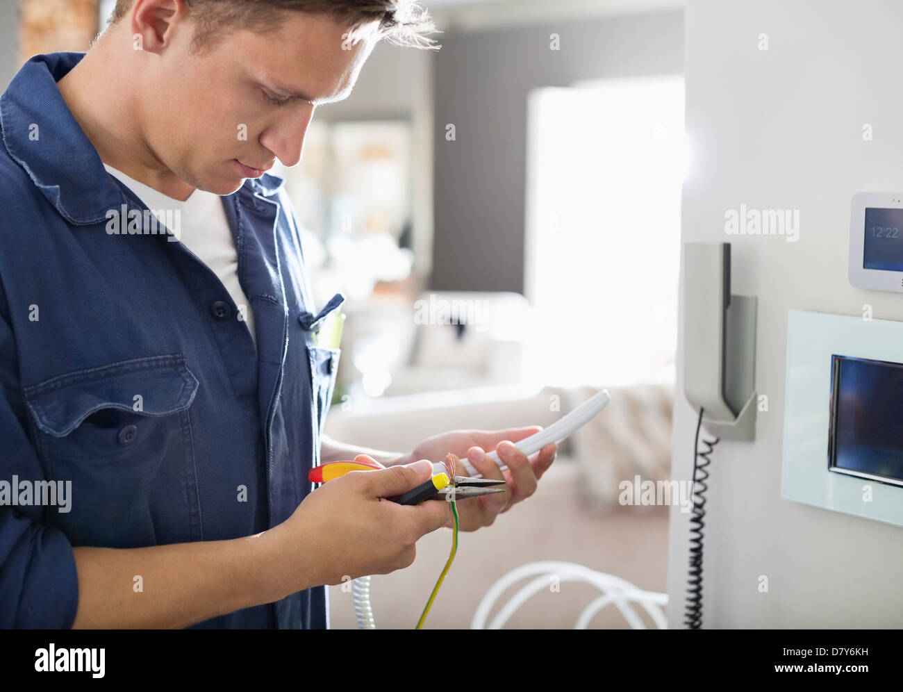 Elektriker arbeiten am Telefon im Haus Stockfoto