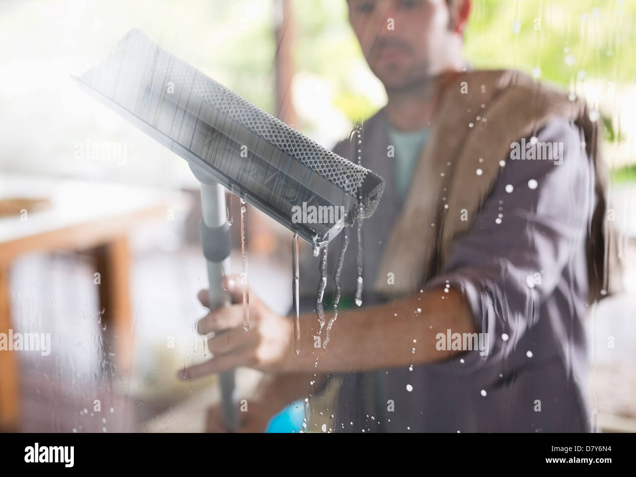 Mann Waschen Fenster mit Rakel Stockfoto