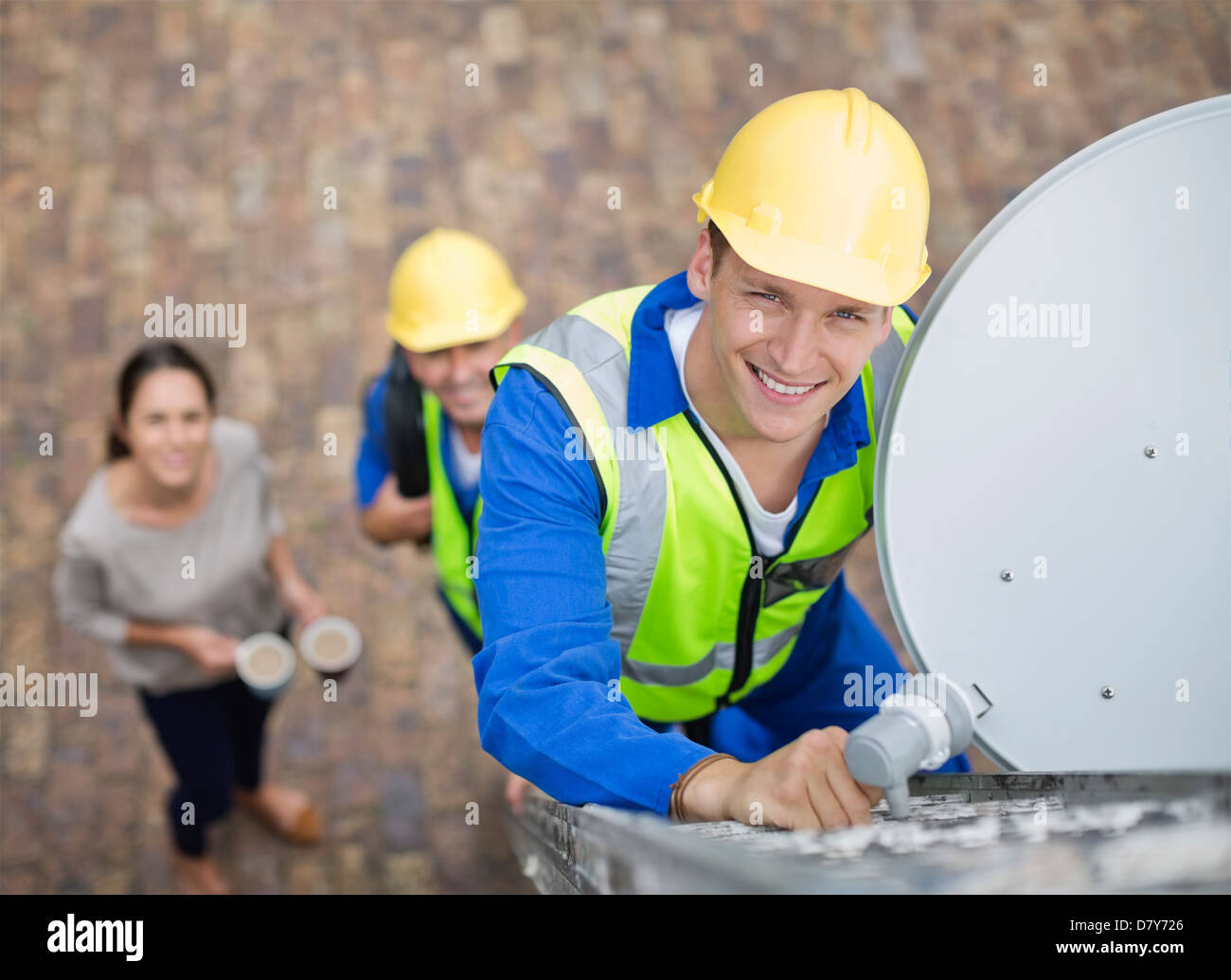 Arbeitnehmer, die Installation von Sat-Schüssel auf Dach Stockfoto