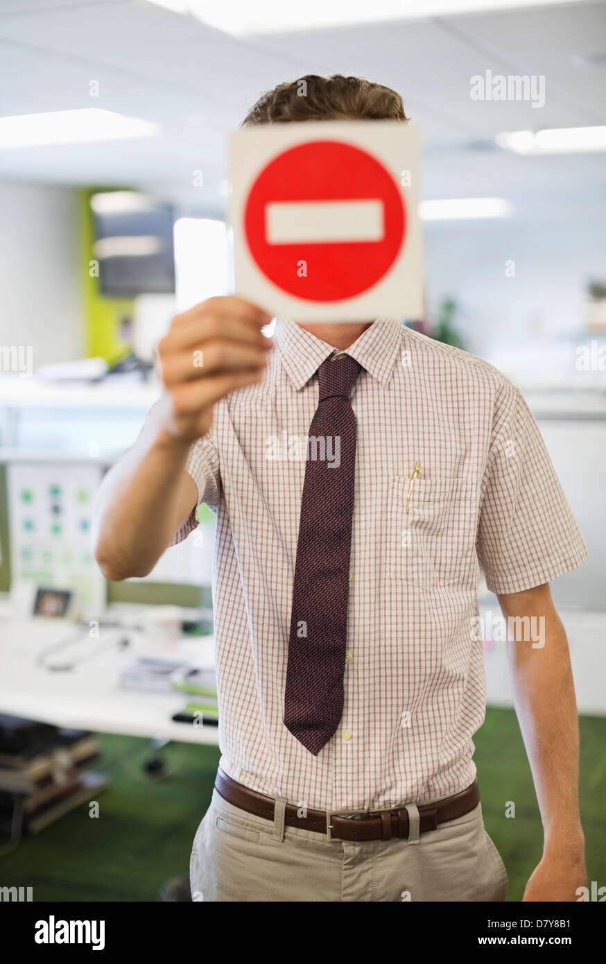 Geschäftsmann hält Warnzeichen im Büro Stockfoto