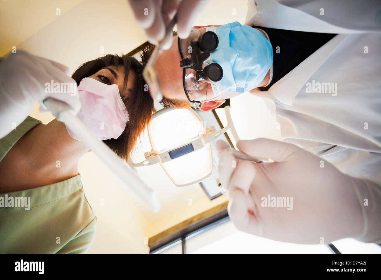 Zahnarzt und Krankenschwester towering über Patienten im Büro Stockfoto