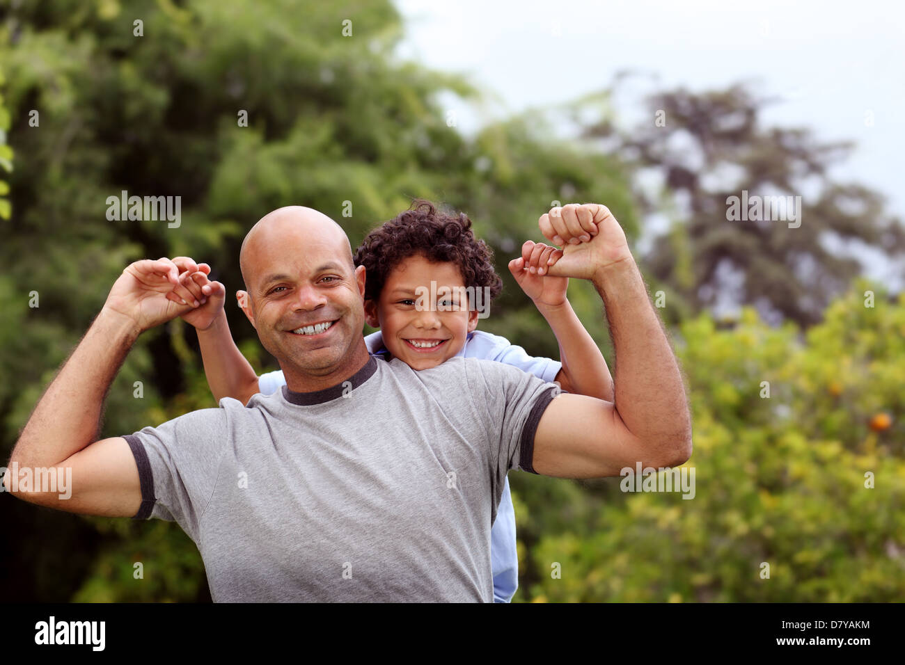 Mischlinge-Vater und Sohn im Garten hinter dem Haus spielen Stockfoto