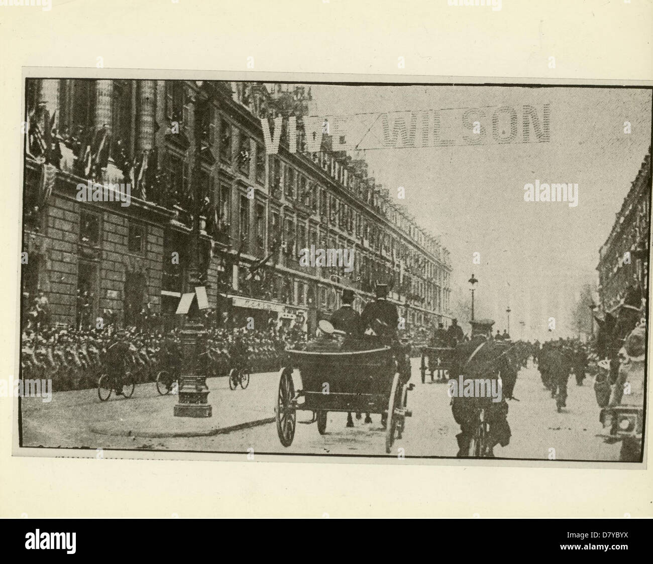 Das Bild repräsentiert einen Moment in der Geschichte während einer Parade in Paris, bei der die Unterzeichnung des vierzehn-Punkte-Friedensplans gefeiert wird. Wilson, wahrscheinlich Präsident Woodrow Wilson, wird als Anführer einer Kutsche durch die Rue Royale gesehen, als Teil der Feierlichkeiten für Friedensverhandlungen nach dem Ersten Weltkrieg Stockfoto