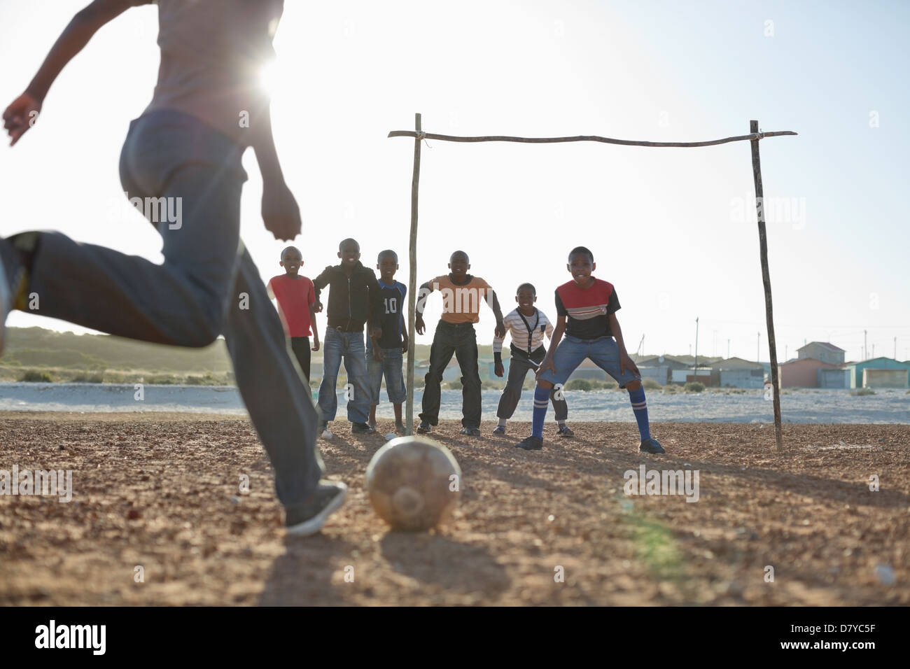 Jungs spielen Fußball zusammen in Schmutz Feld Stockfoto