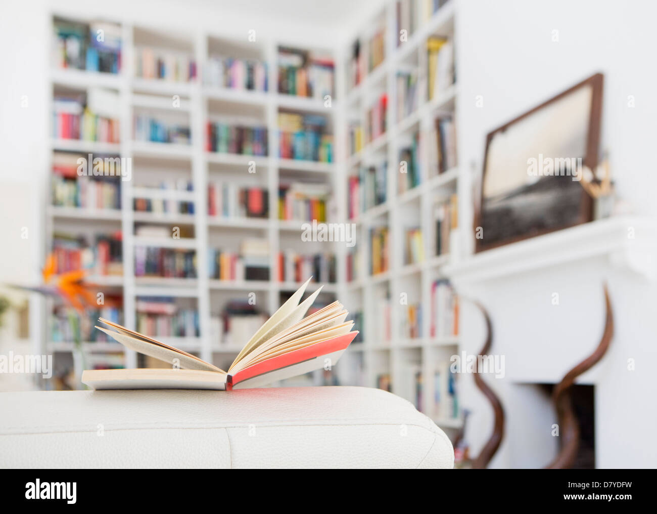 Offenes Buch am Arm des Sofas im Wohnzimmer Stockfoto