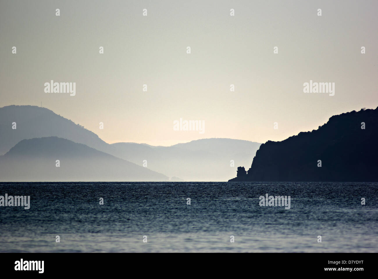 Sonnenuntergang am Meer, Schloss blaue Landschaft, neblige Inseln entfernt. Stockfoto