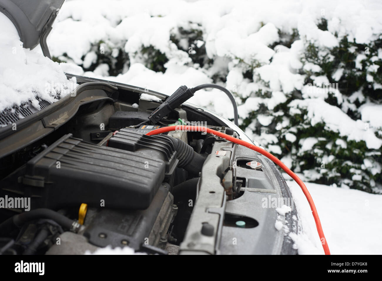Leitungen auf Autobatterie im Schnee Stockfoto