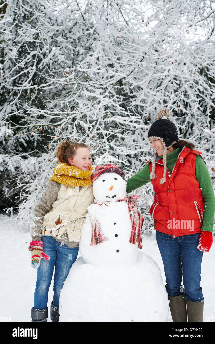 Mutter und Tochter mit Schneemann Stockfoto