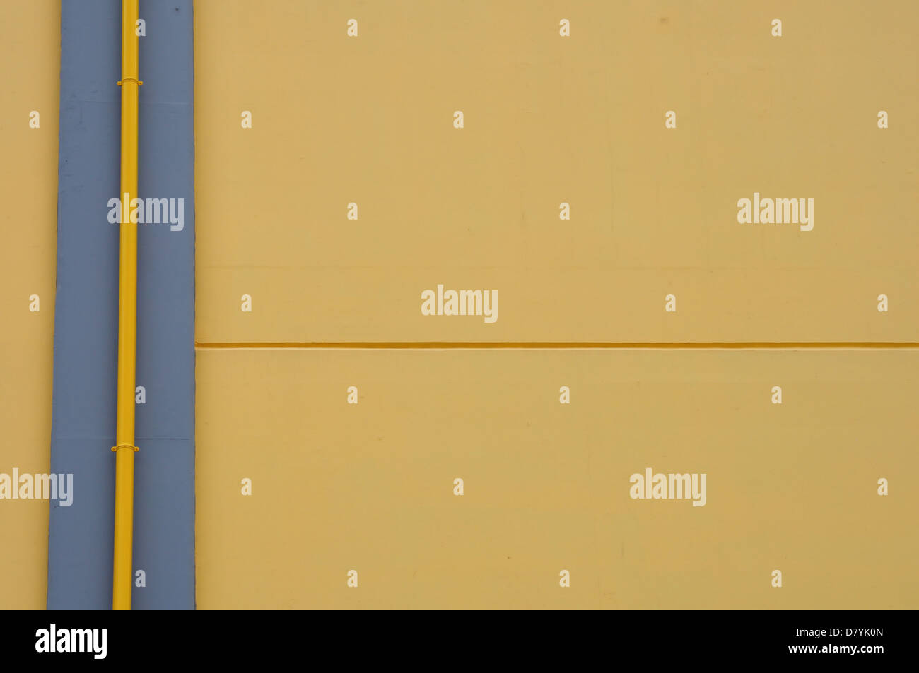 Gelbe Wand und Abfluss Rohr Hintergrund. Abstrakte Architekturdetail. Stockfoto