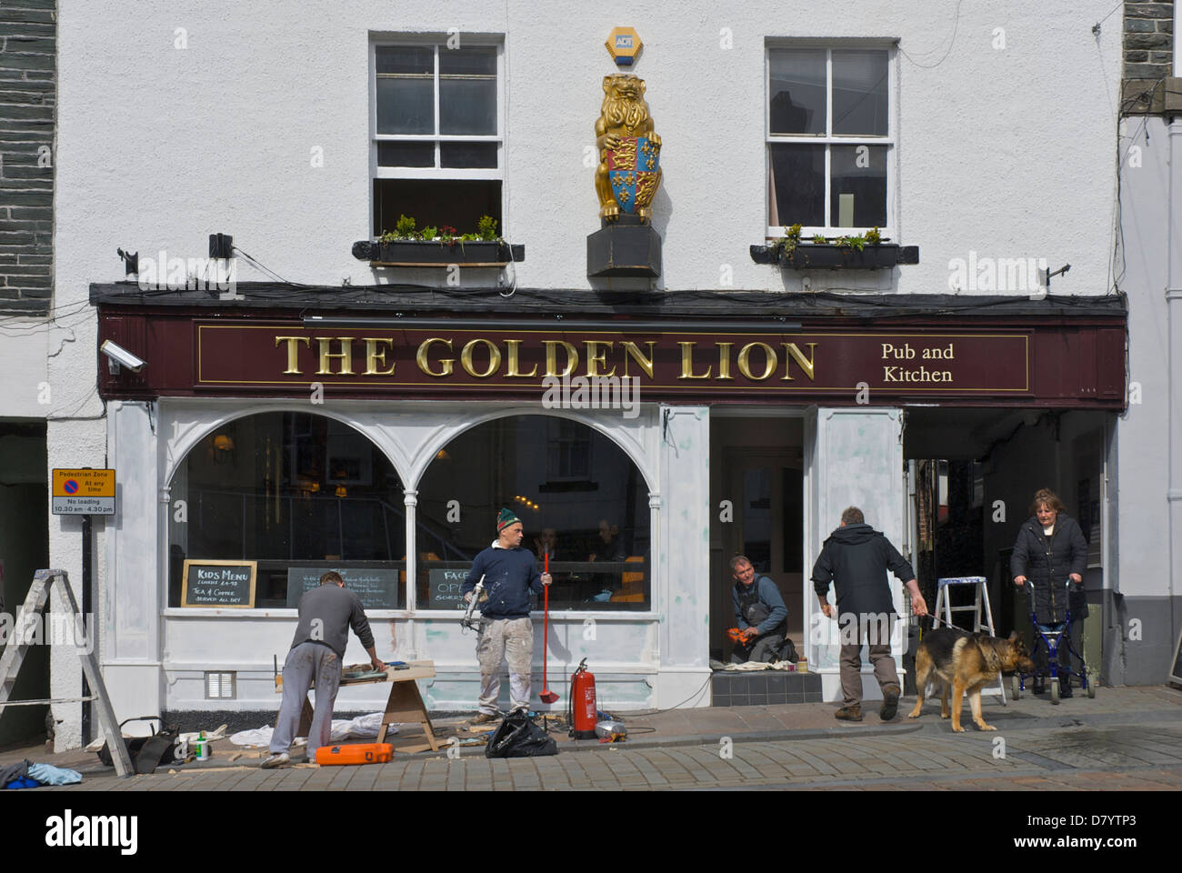 Männer Neuanstrich der Fassade des Golden Lion Pub, in der Stadt Keswick, Nationalpark Lake District, Cumbria, England UK Stockfoto