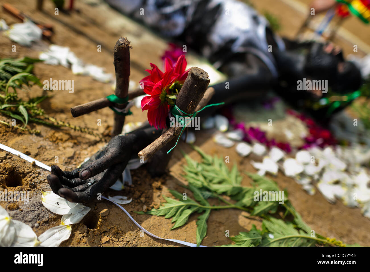 Diana R., der behauptet, von Geistern besessen werden, liegt auf dem Boden, während ein Ritual des Exorzismus von Blumen umgeben. Stockfoto
