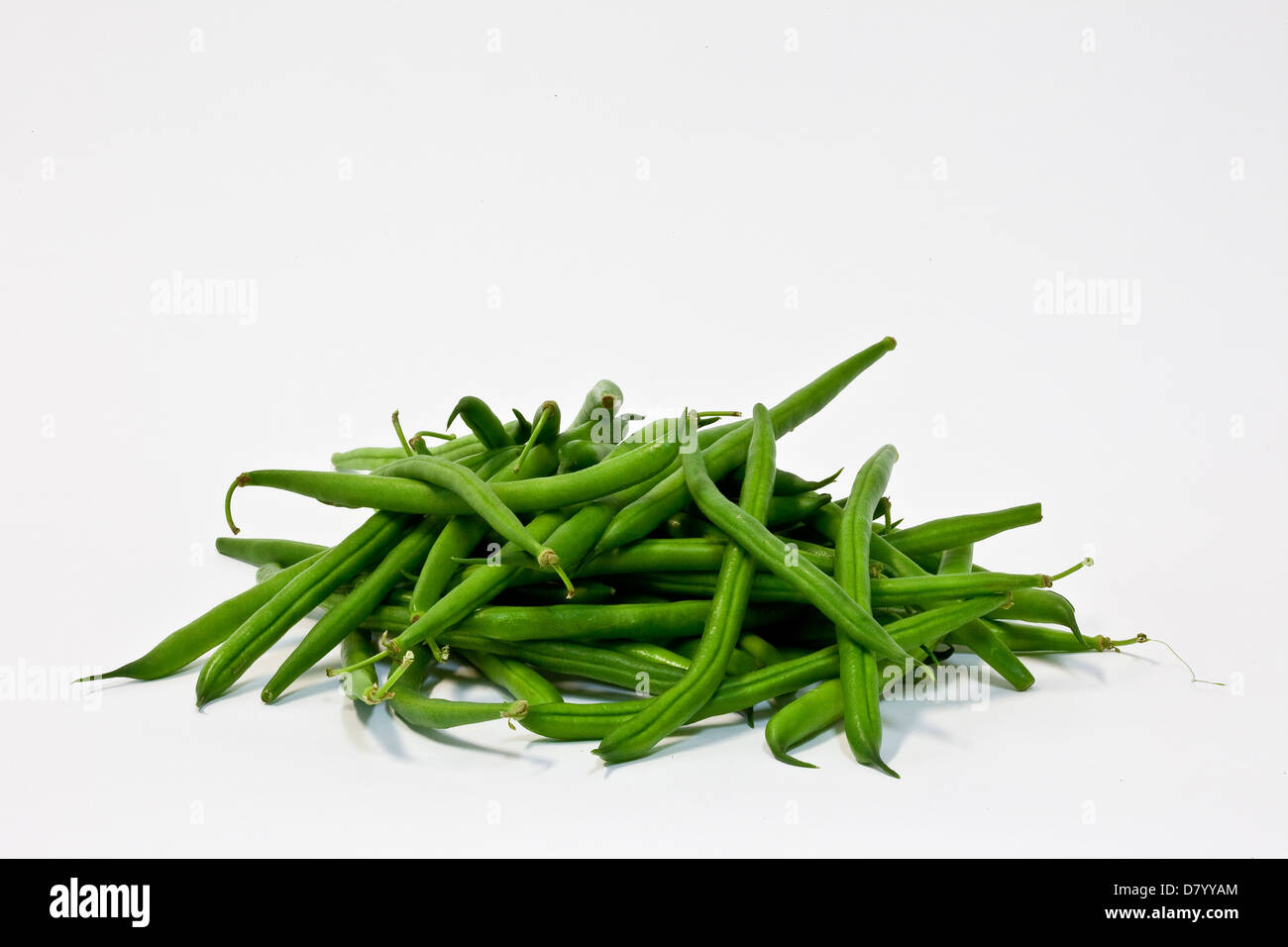 Ein Haufen von frischen grünen Bohnen vor einem weißen Hintergrund. Stockfoto