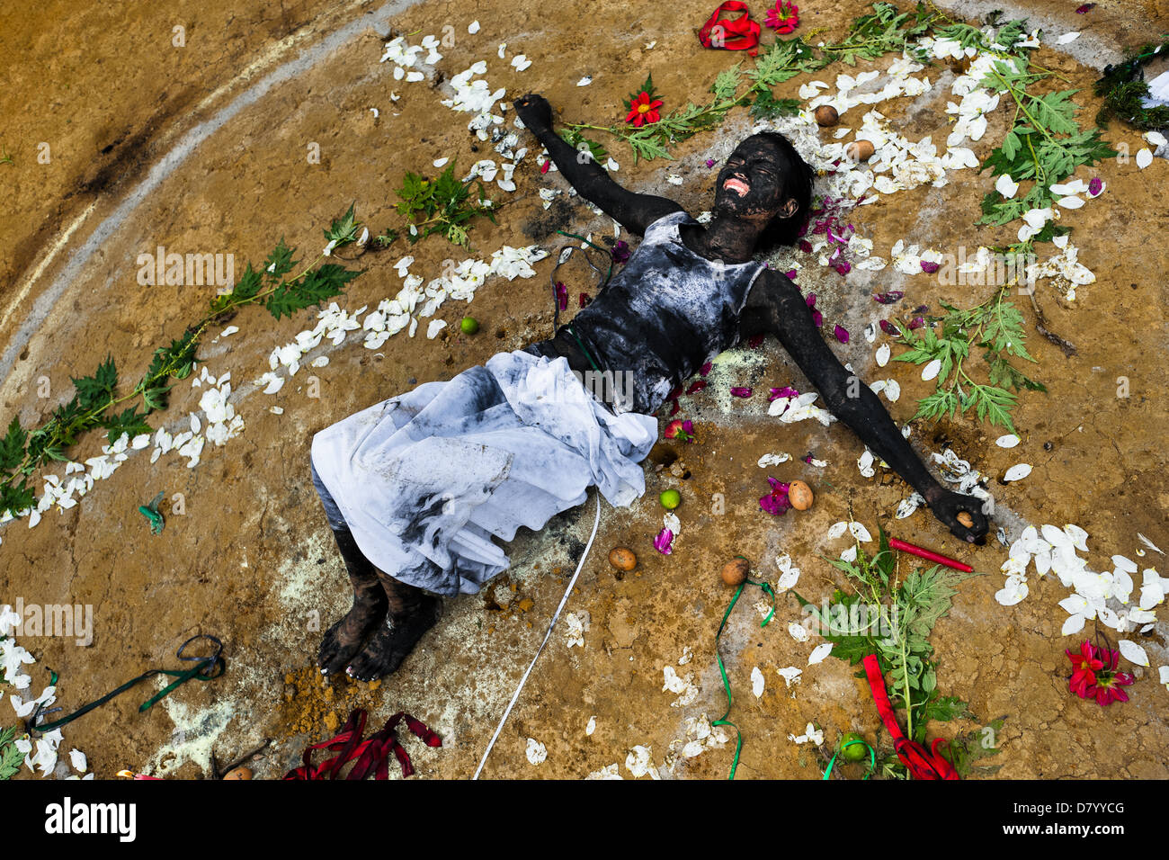 Diana R., der Ansprüche von Geistern besessen, auf dem Boden liegt umgeben von Blumen nach einem Ritual des Exorzismus. Stockfoto