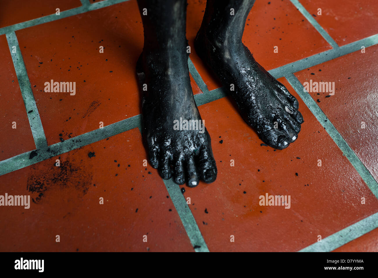Füße von Diana R., der behauptet, von Geistern, gesehen besessen werden abgedeckt durch schwarzen Schlamm vor einem Ritual des Exorzismus in Kolumbien. Stockfoto