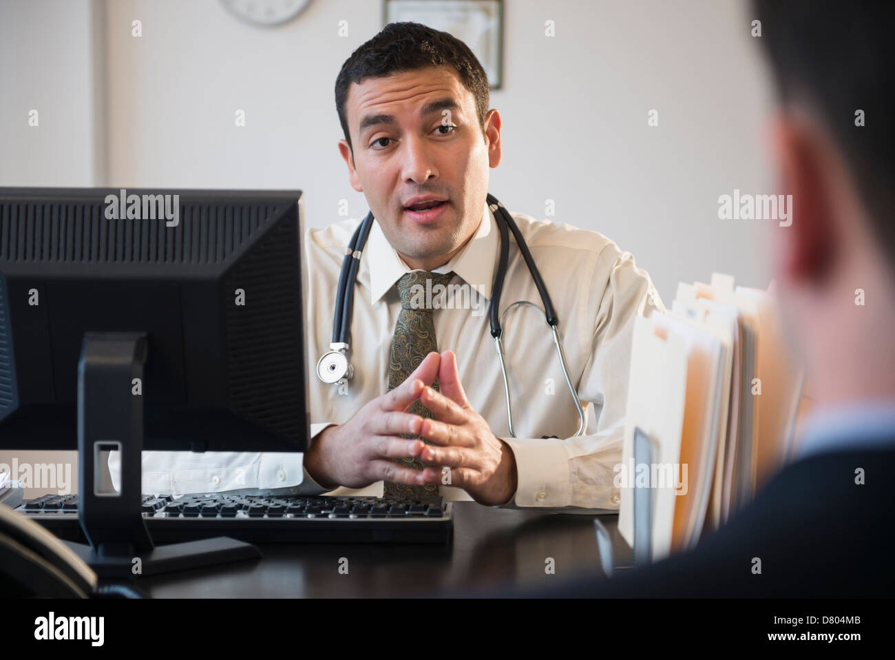 Arzt im Gespräch mit Kunden im Büro Stockfoto