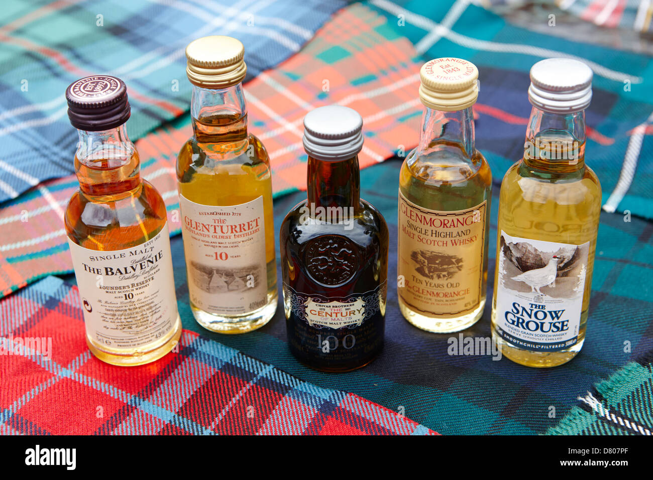 Auswahl an Miniatur Scotch Whiskys und traditionellen schottischen Clan tartans Stockfoto