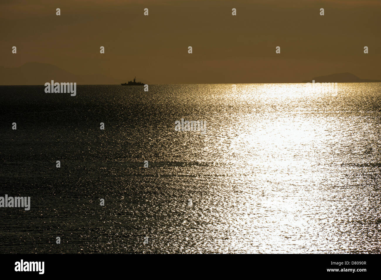 Goldene orange Sonnenuntergang mit Reflexionen und Fischerboot, Ägäis, Kalymnos, Griechenland Stockfoto