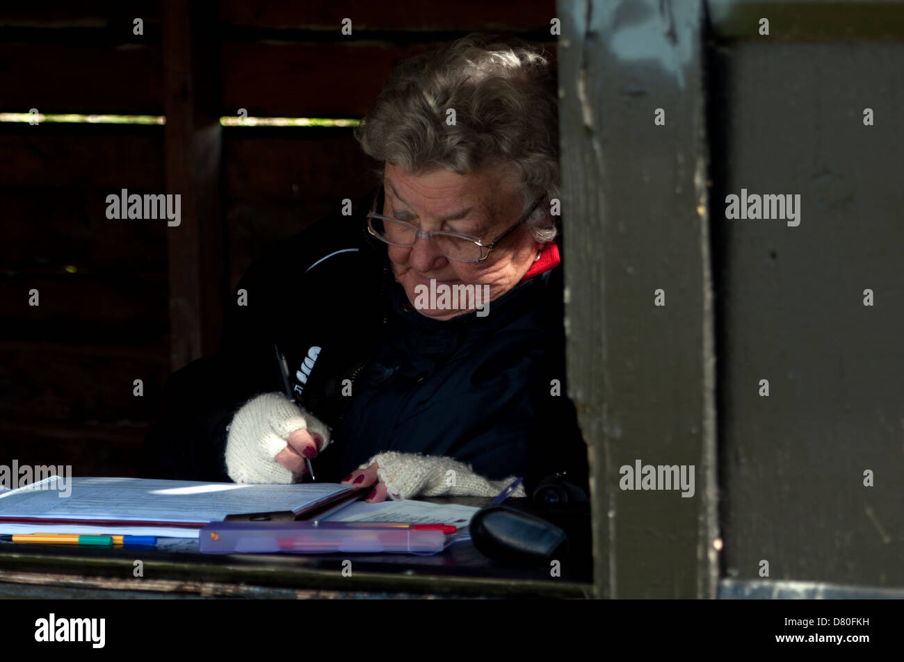 Frau scoring bei Dorf Cricket Match, Kineton, Warwickshire, England, UK Stockfoto