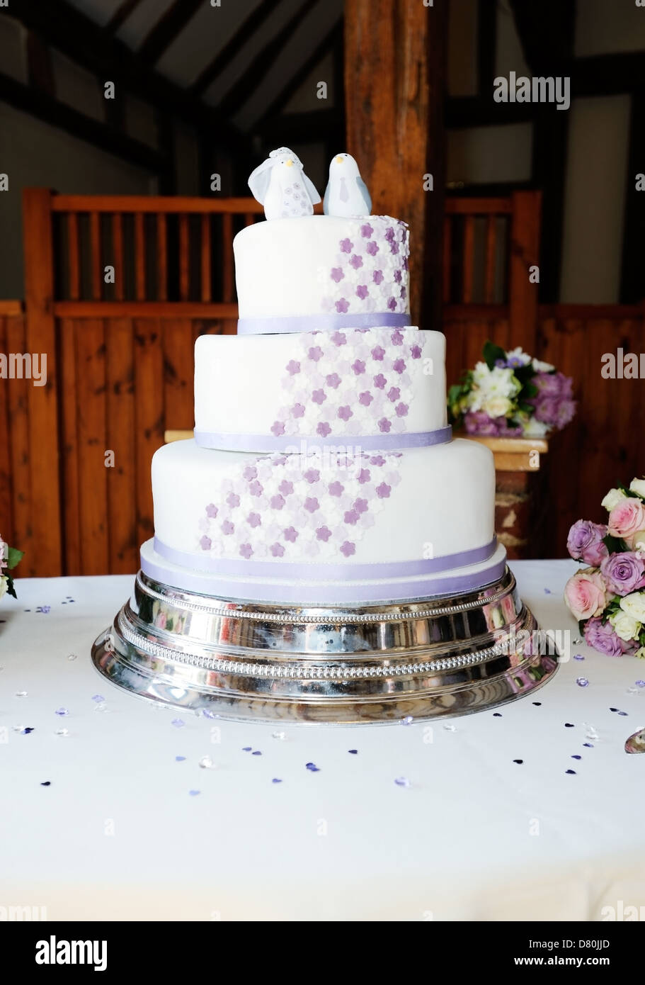 Hochzeitstorte auf Tisch an der Rezeption mit Bräute Blumen Stockfoto