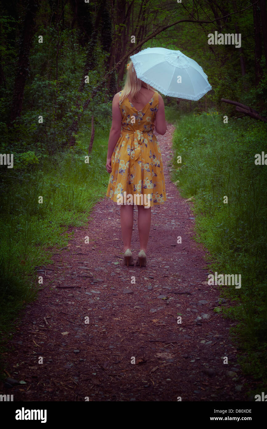 ein Mädchen mit einem Regenschirm im Wald Stockfoto