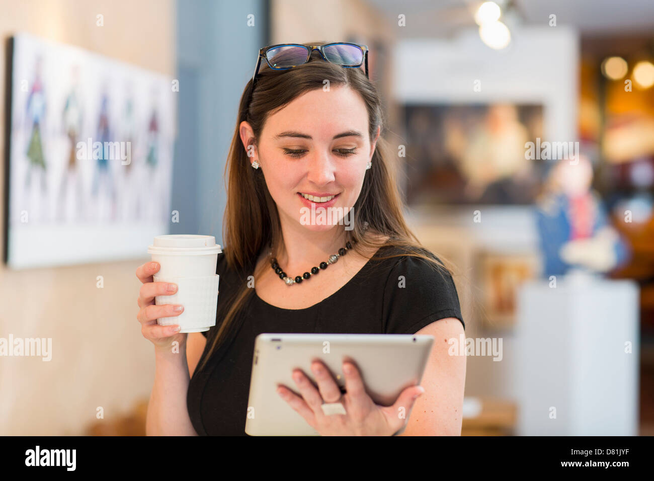 Kaukasische Frau mit Tablet-PC in Kunstgalerie Stockfoto