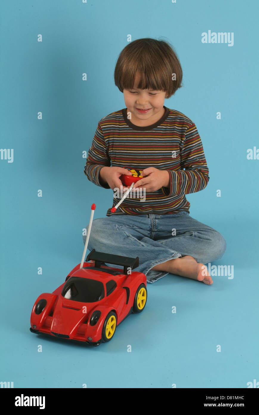 Kind spielt mit einem remote gesteuerten Spielzeugauto Stockfoto