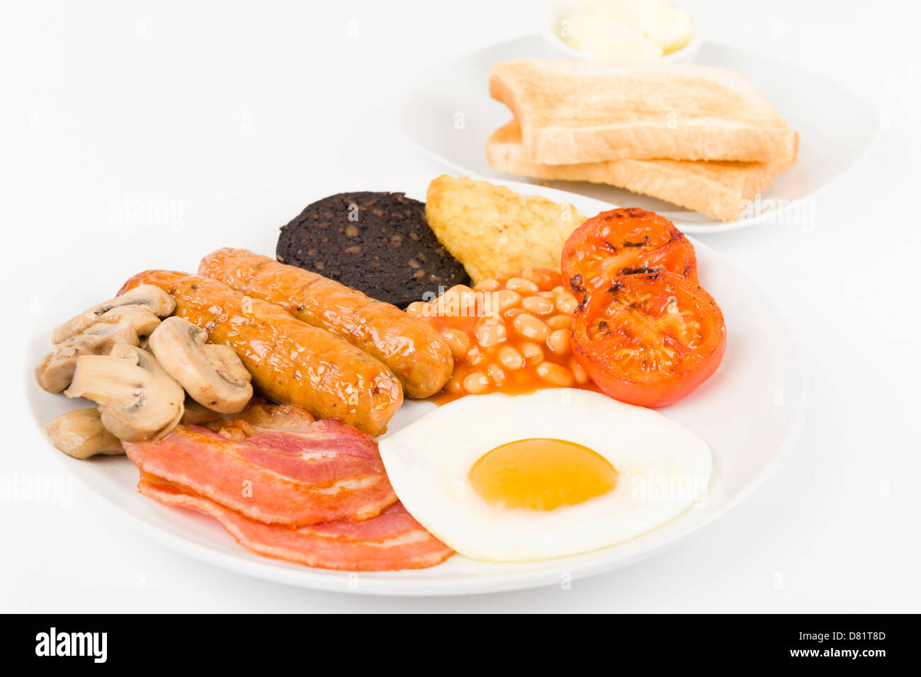 Full English Breakfast - Fry-up mit Ei, Speck, Champignons, Tomaten, Würstchen, Black Pudding, Rösti und gebackene Bohnen. Stockfoto