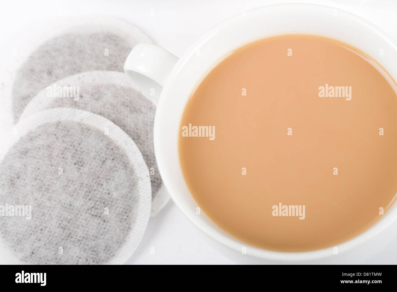 Tasse Tee - einfache Tasse Tee mit Milch und Teebeutel auf einem weißen Hintergrund von oben geschossen. Stockfoto