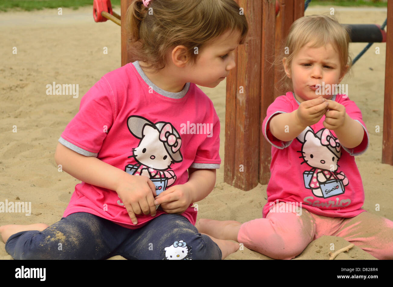 2 und 4 Jahre alte Mädchen in Sand Grube spielen Spielzeug Spielplatz Stockfoto
