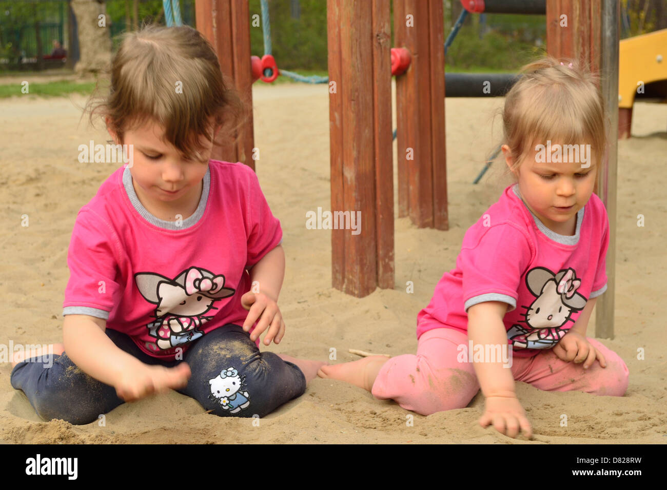 2 und 4 Jahre alte Mädchen in Sand Grube spielen Spielzeug Spielplatz Stockfoto