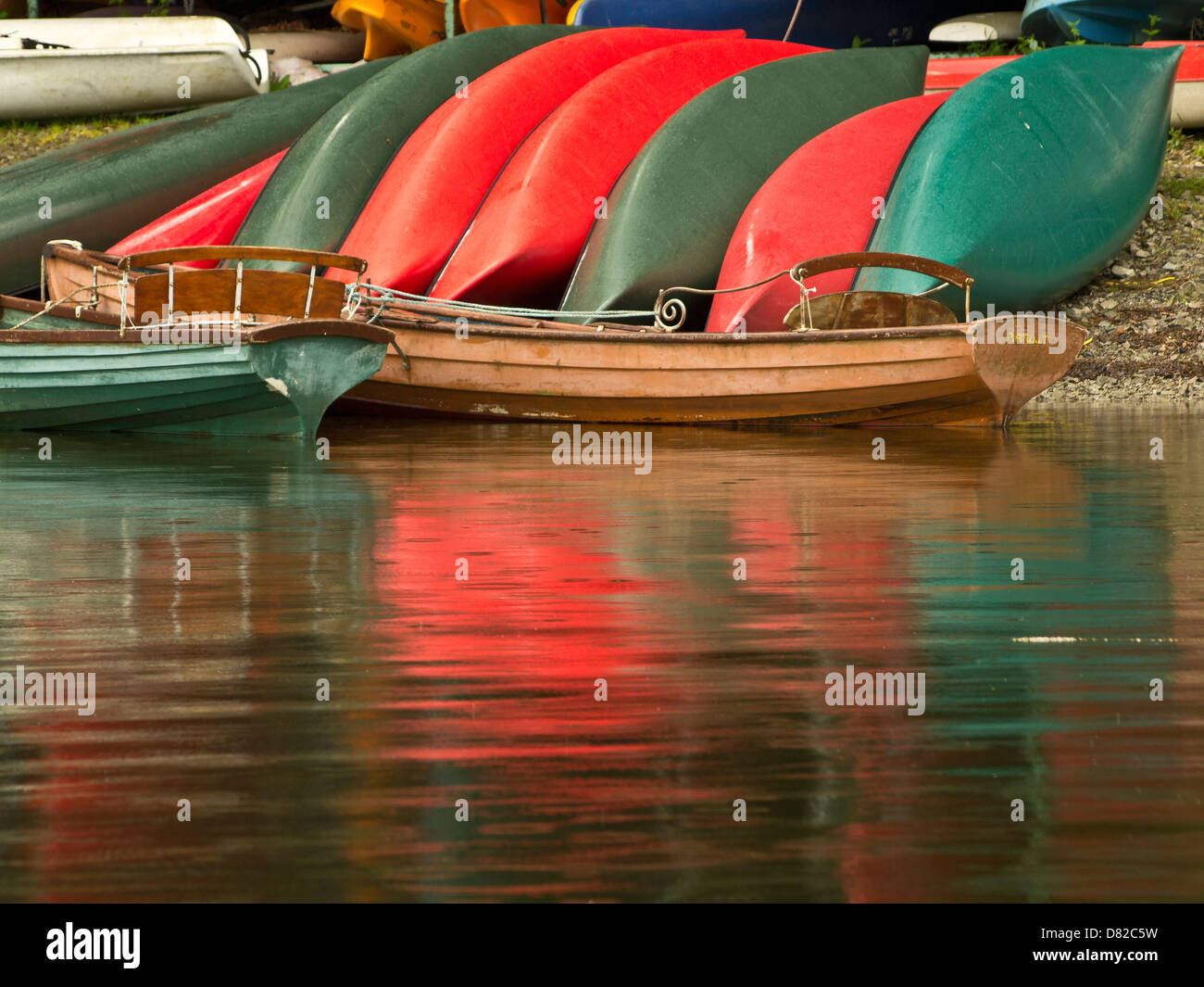 Rot und grün bunt leuchtende Boote am Ufer des Sees, Nicol Ende, Lake District, Cumbria, UK Stockfoto