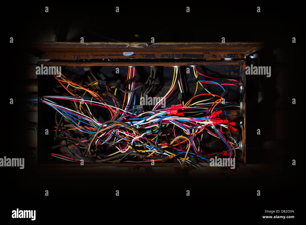 alten Sicherungskasten mit Durcheinander von Drähten, Kabeln farbig codierte in verrückte Richtungen planlos chaotisch ungeordnetes durcheinander Stockfoto