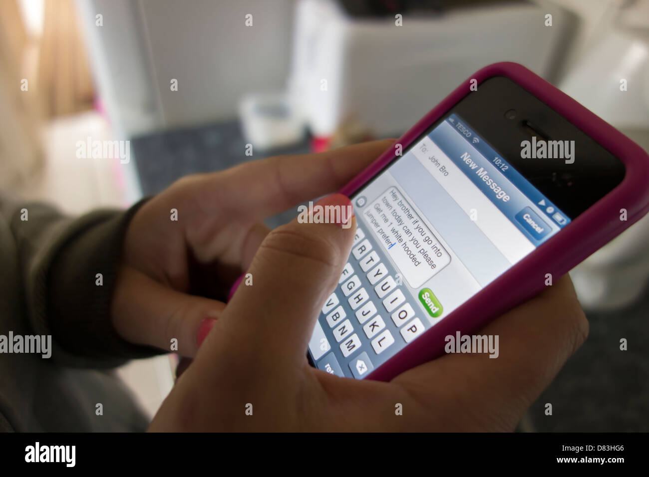 Weiblich, Schreiben einer Kurzmitteilung auf dem iphone Stockfoto