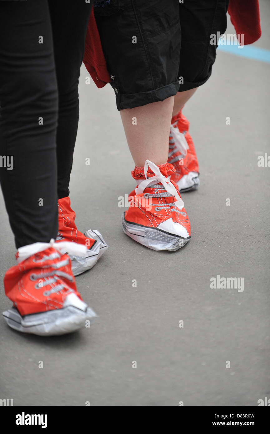 Tower Bridge, London, UK. 18. Mai 2013. Wanderer mit Slip in roten Schuhen auf Tower Bridge. Red Shoe gehen zugunsten der Rot-Kreuz-Woche, eine Wohltätigkeitsorganisation gehen durch die Londoner, mit den Wanderern tragen rote Schuhe oder Slip über rote Abdeckungen. Bildnachweis: Matthew Chattle / Alamy Live News Stockfoto