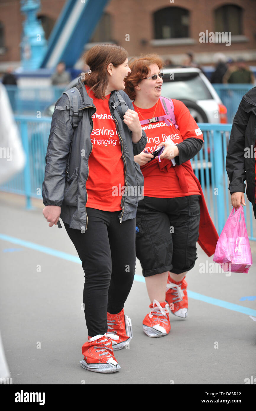 Tower Bridge, London, UK. 18. Mai 2013. Wanderer mit Slip in roten Schuhen auf Tower Bridge. Red Shoe gehen zugunsten der Rot-Kreuz-Woche, eine Wohltätigkeitsorganisation gehen durch die Londoner, mit den Wanderern tragen rote Schuhe oder Slip über rote Abdeckungen. Bildnachweis: Matthew Chattle / Alamy Live News Stockfoto