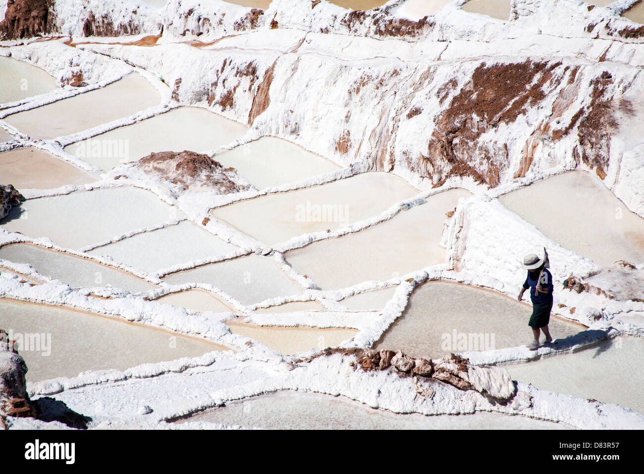 Eine Frau arbeitet in das Salz in Maras, Peru Pfannen. Stockfoto