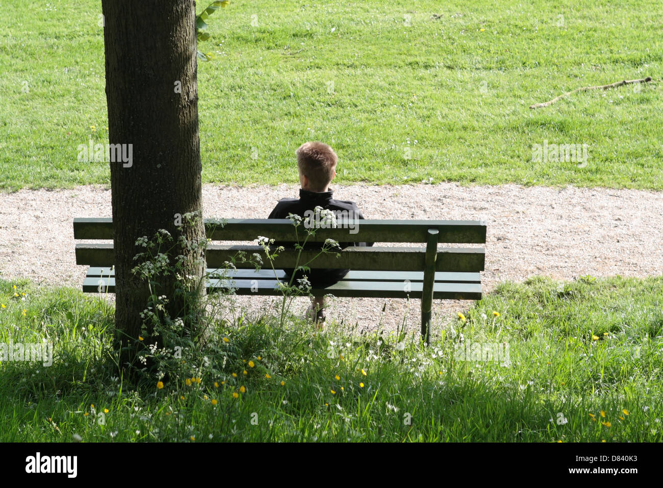 Junge Dame ruht auf einer Bank in einem Park in Elburg, Niederlande Stockfoto