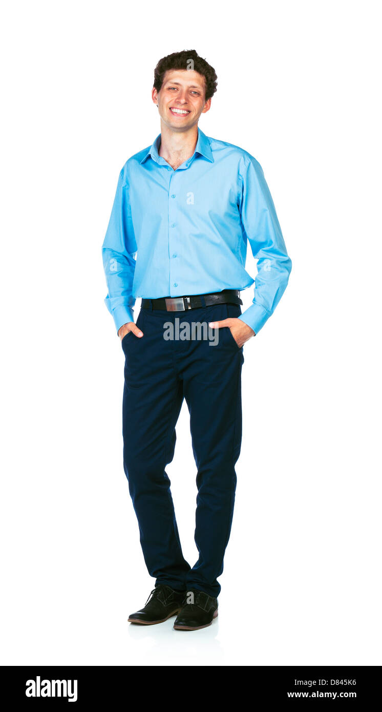 Glückliche junge Geschäftsmann stehend mit den Händen in den Taschen auf weißem Hintergrund Stockfoto