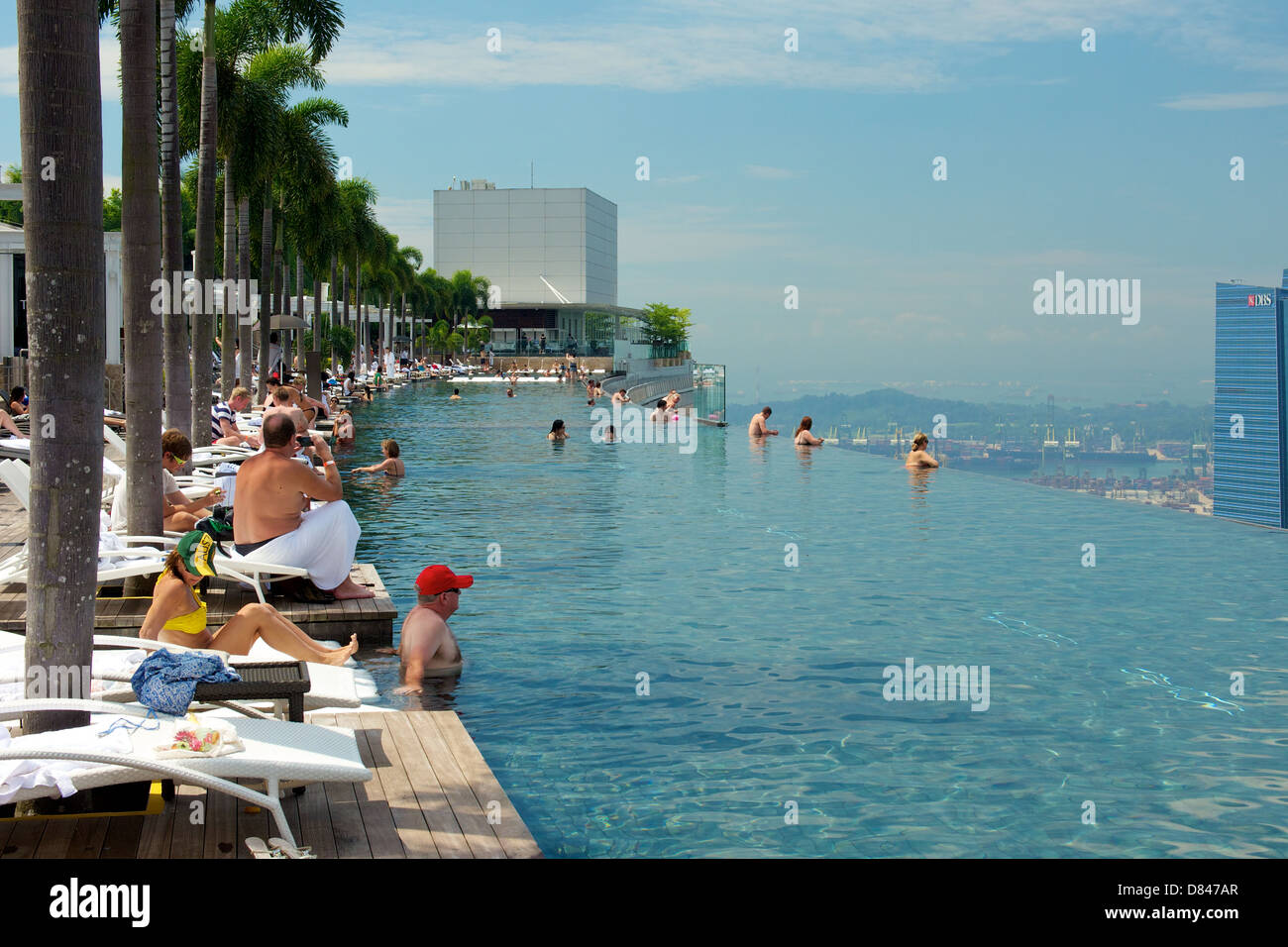 Gast des Marina Bay Sands Hotel Chillen am Infinity-Pool auf dem Dach einweichen in der Nachmittagssonne und Sehenswürdigkeiten Stockfoto
