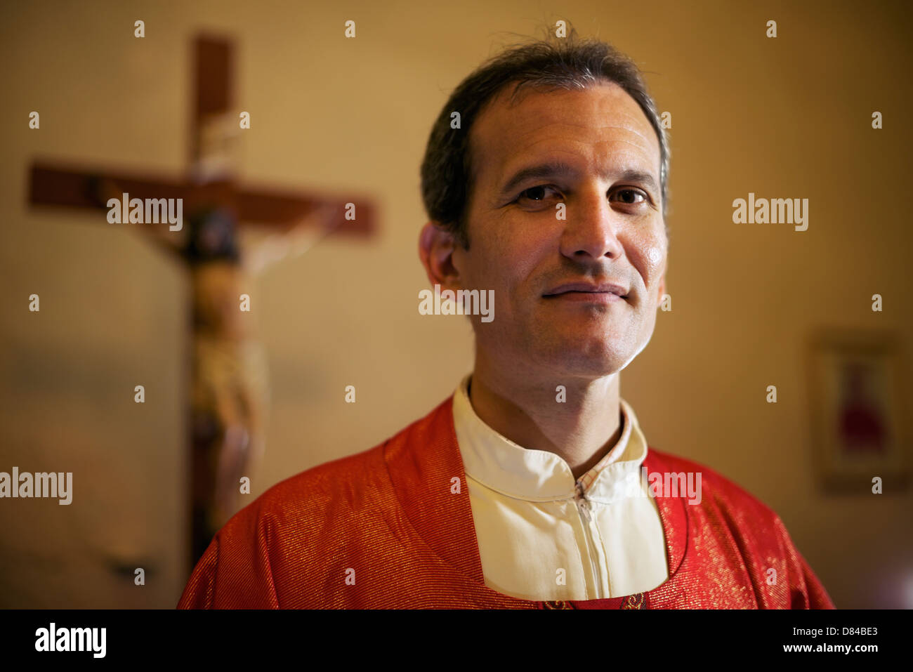 Mann und glauben, Porträt von katholischer Priester am Altar in der Kirche Blick in die Kamera und lächelnd Stockfoto