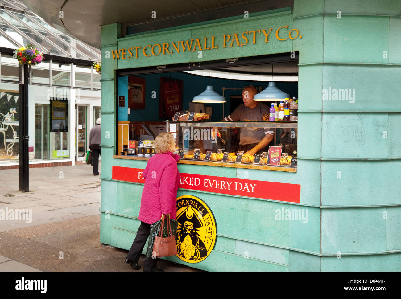 Eine Frau, der Kauf von Lebensmitteln aus einem West Cornwall Pasty Co. Café Shop, York, UK Stockfoto