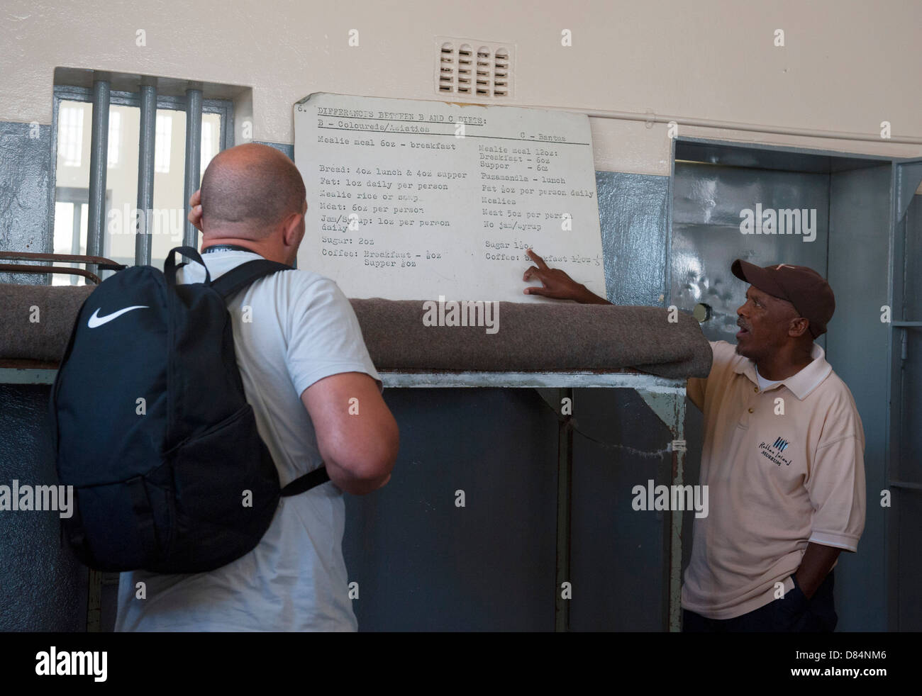 Ein ehemaliger politischer Gefangener aus der Zeit der Apartheid zeigt Touristen auf Robben Island Gefängnis, Cape Town, Südafrika. Stockfoto