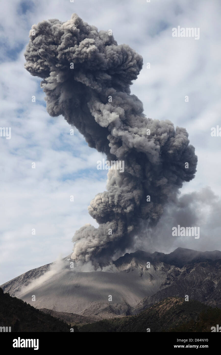 25. Februar 2013 - Explosive Eruption des Vulkans Sakurajima, Japan. Aschewolke erhebt sich hoch über dem Vulkan und ist durch den Wind gebeugt. Stockfoto