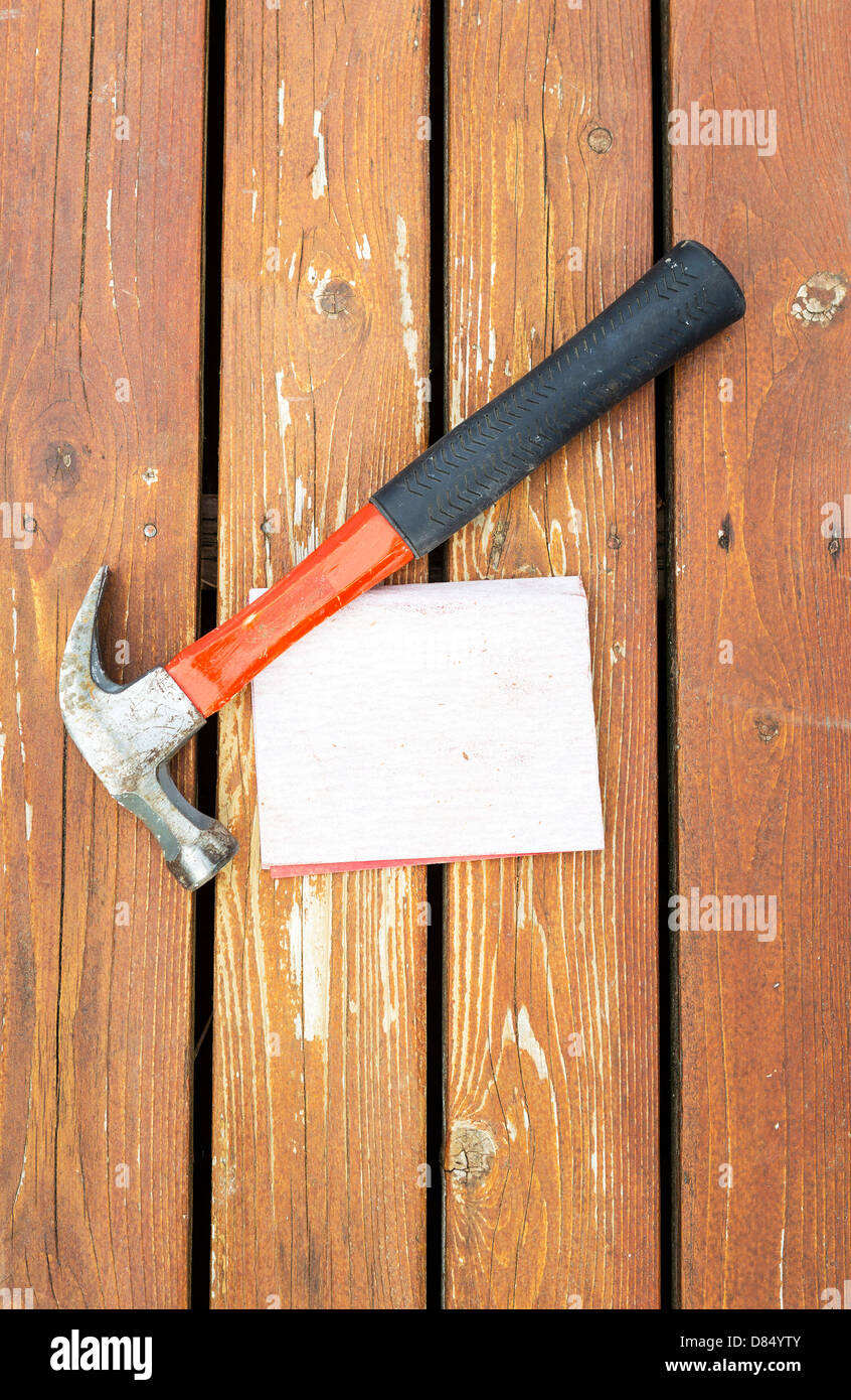 Vertikale Foto Arbeit Hammer und Sand Papier auf natürliche verblasste Zeder Holz-deck Stockfoto