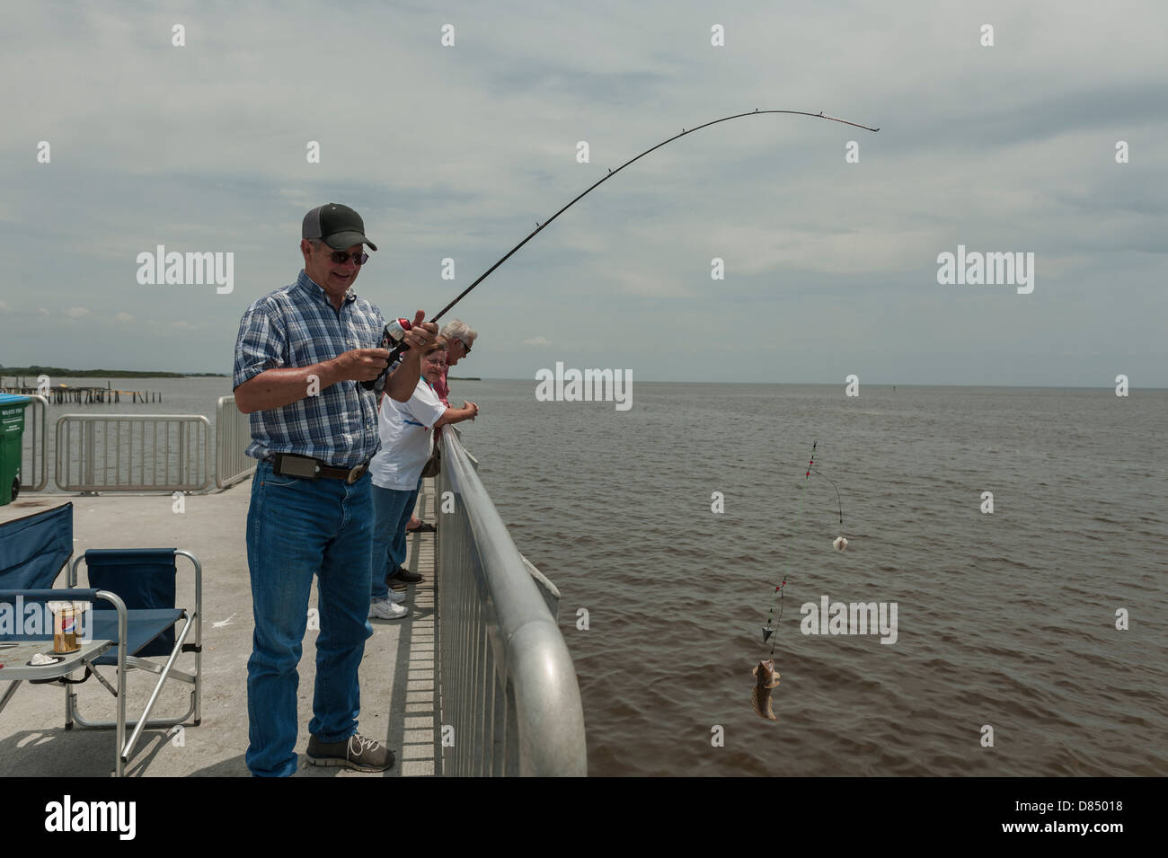 Mann, die Kokons in einem Fisch auf dem öffentlichen Steg auf Cedar Key Florida an der Golfküste Stockfoto