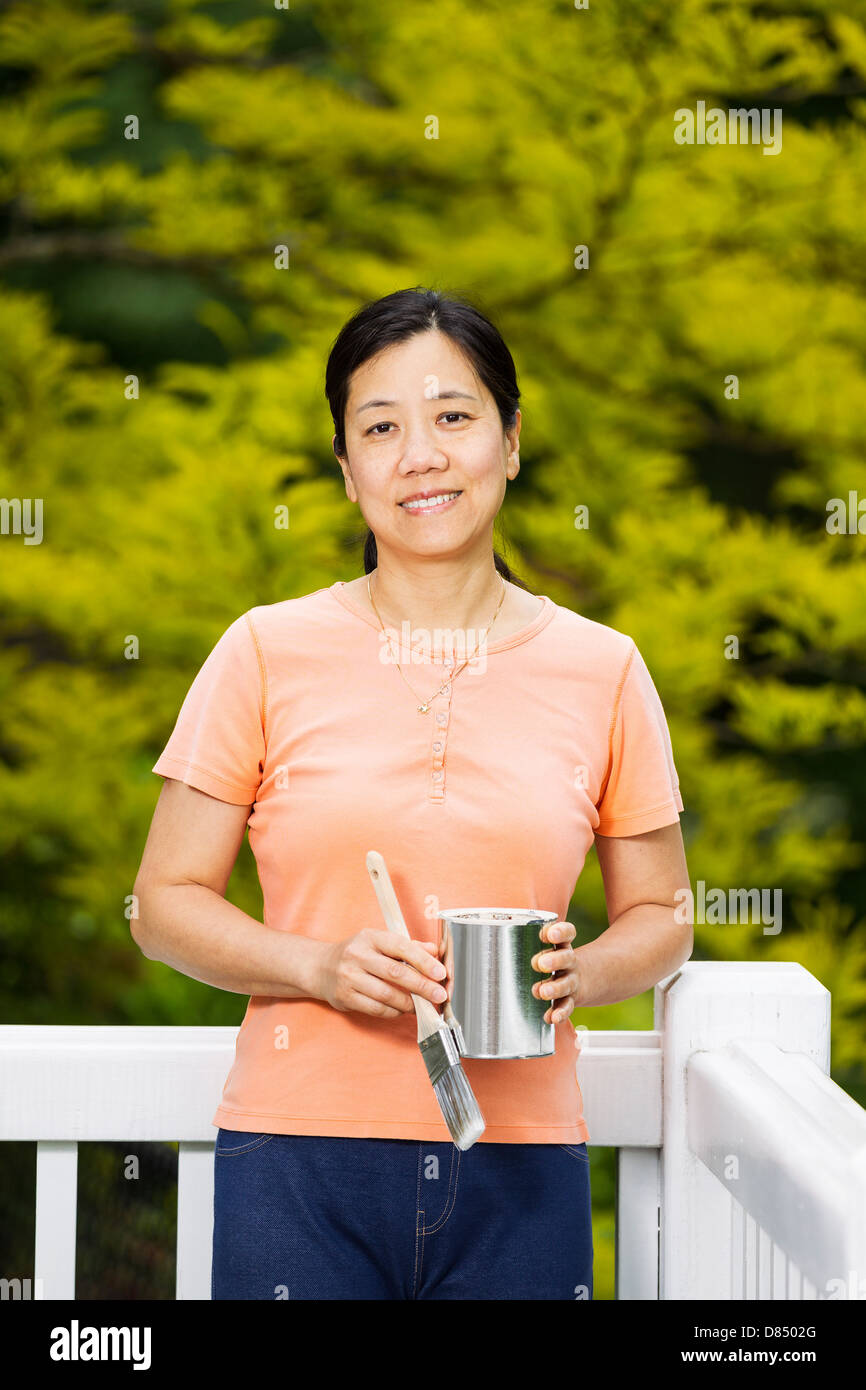 Reife Frau vorbereiten, ihre Terrasse Geländer zu malen Stockfoto