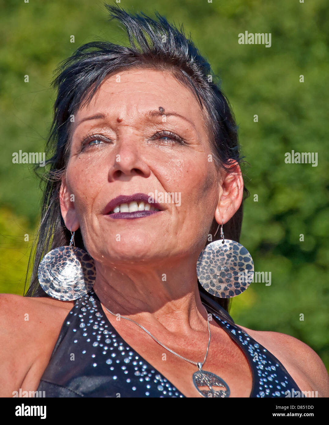 Dies ist ein Porträt einer reifen Frau indianischer Abstammung in einer im Freieneinstellung und groß, Fett Ohrringe. Stockfoto