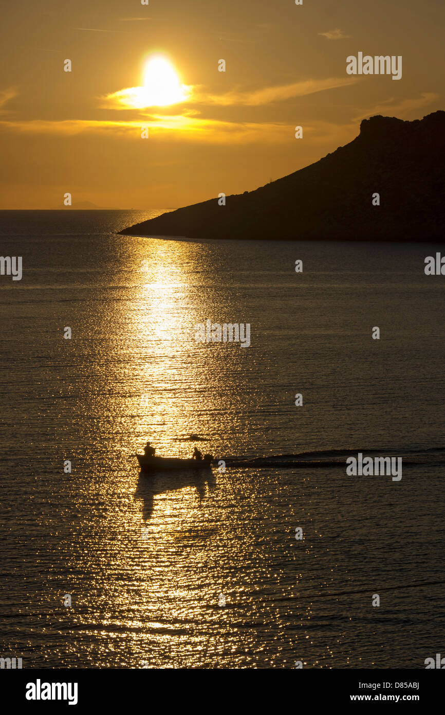 Goldene orange Sonnenuntergang mit Reflexionen und Fischerboot, Ägäis, Kalymnos, Griechenland Stockfoto