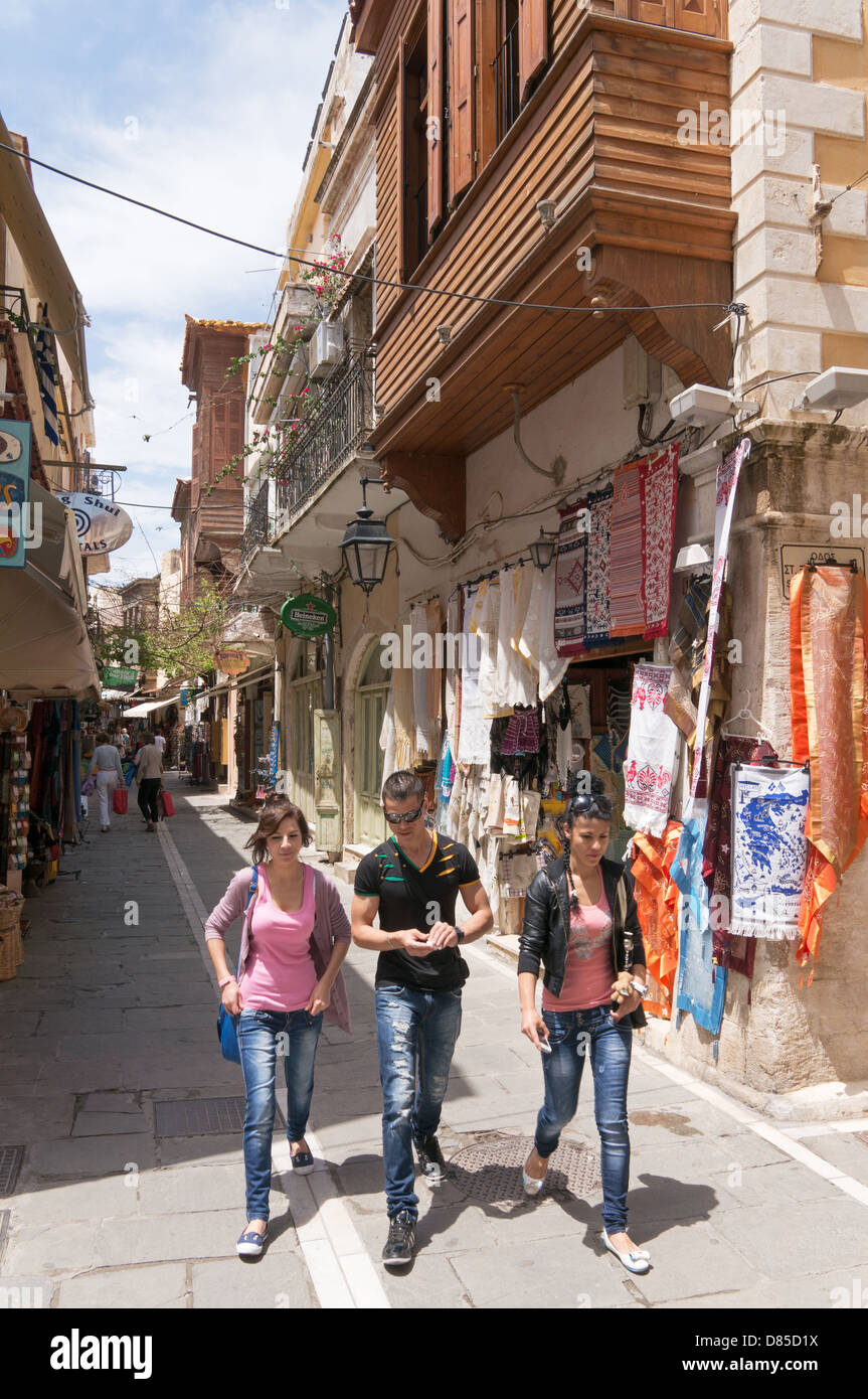 Drei junge Menschen gehen durch eine schmale Straße in der alten Stadt Rethymnon, Crete Stockfoto